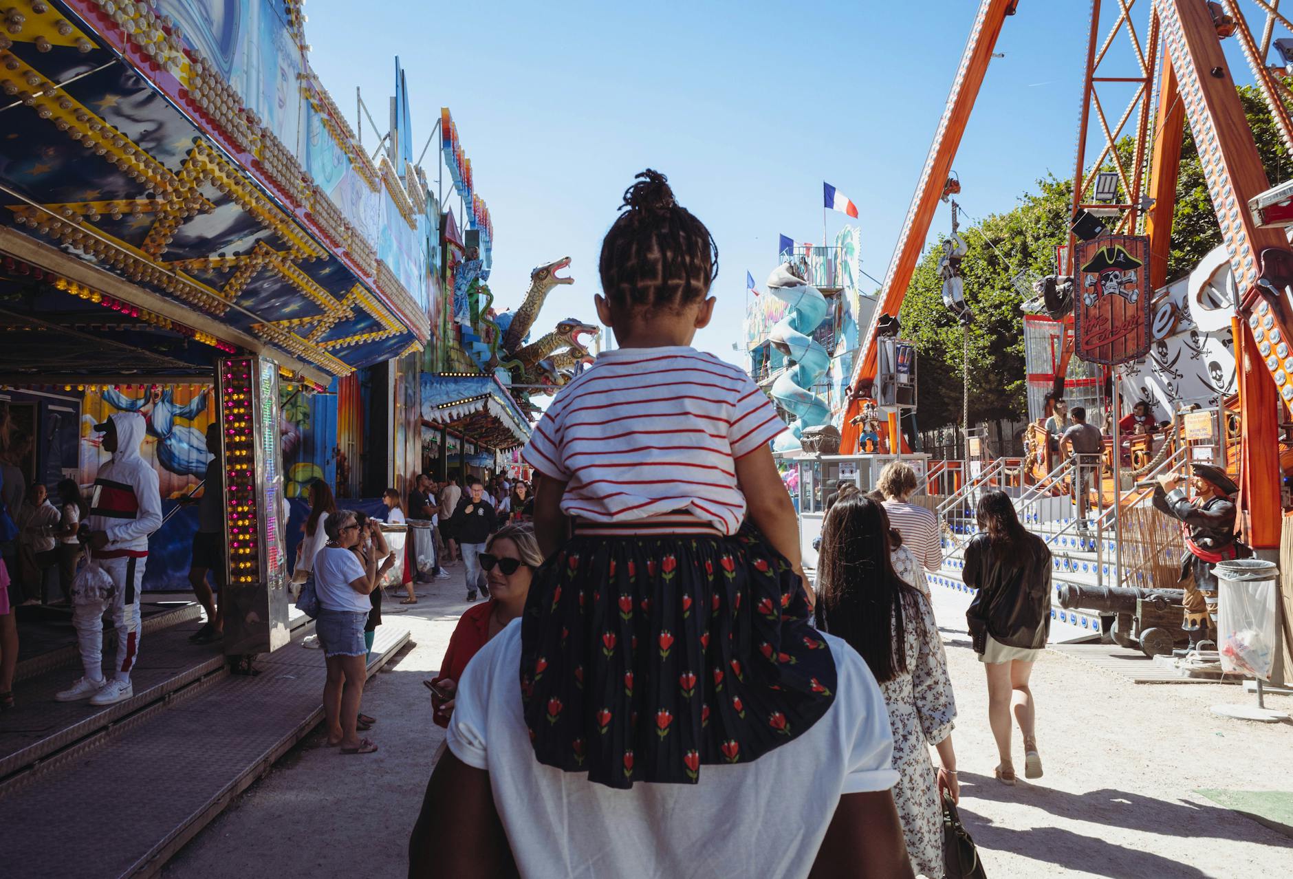father carrying daughter in amusement park