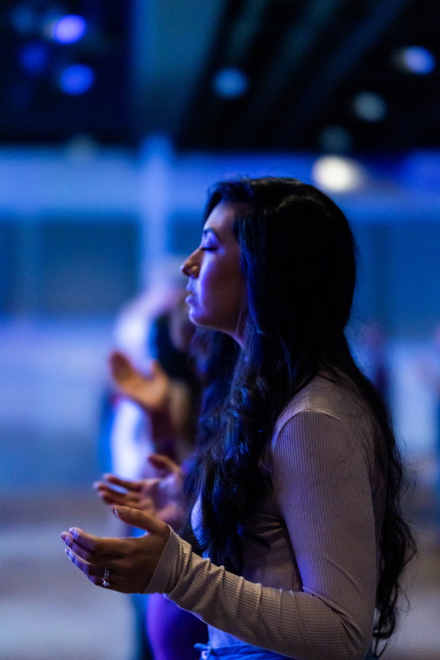 a woman in gray long sleeves praying